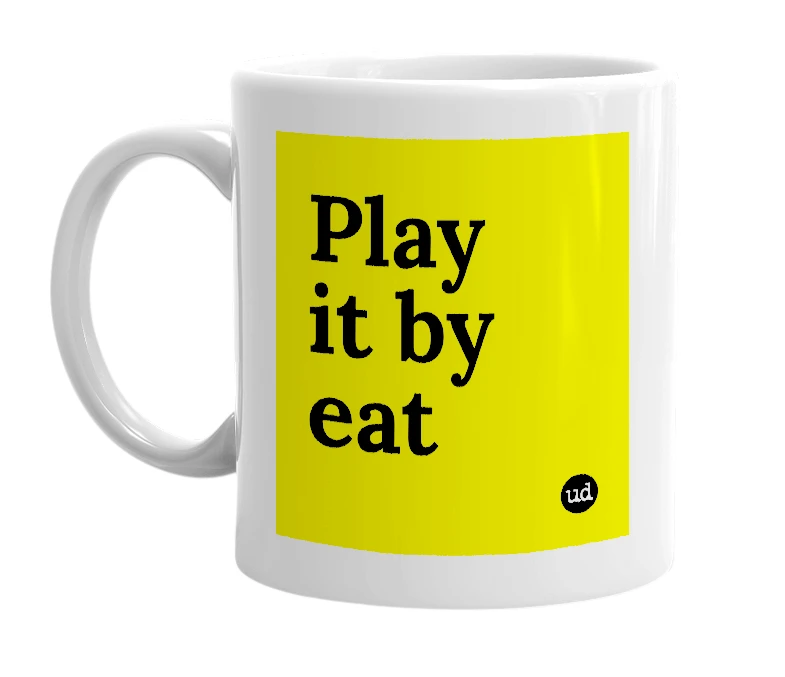 White mug with 'Play it by eat' in bold black letters