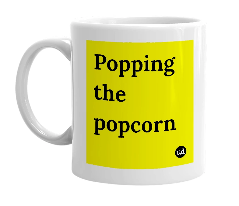 White mug with 'Popping the popcorn' in bold black letters