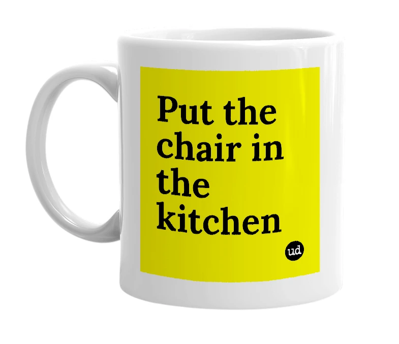 White mug with 'Put the chair in the kitchen' in bold black letters