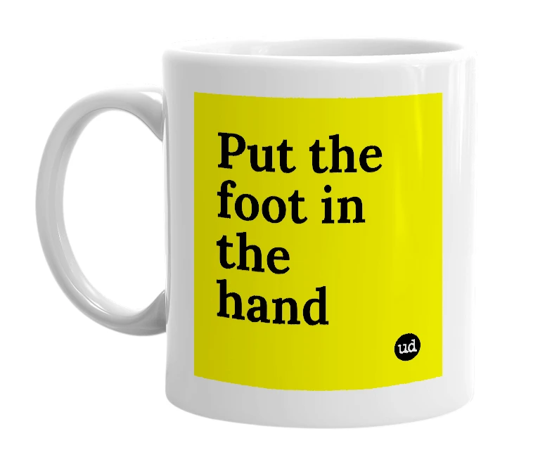 White mug with 'Put the foot in the hand' in bold black letters