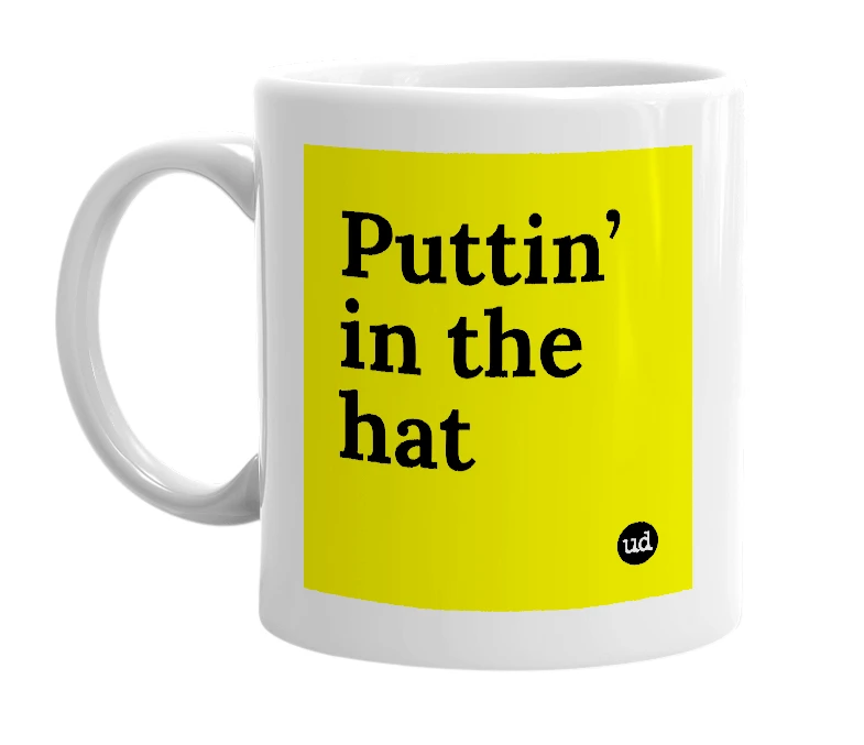 White mug with 'Puttin’ in the hat' in bold black letters