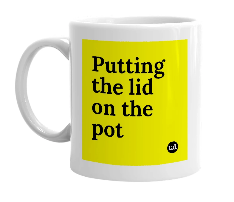 White mug with 'Putting the lid on the pot' in bold black letters