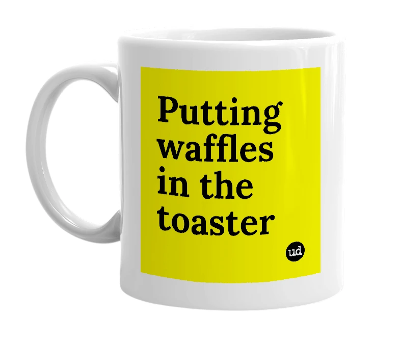 White mug with 'Putting waffles in the toaster' in bold black letters
