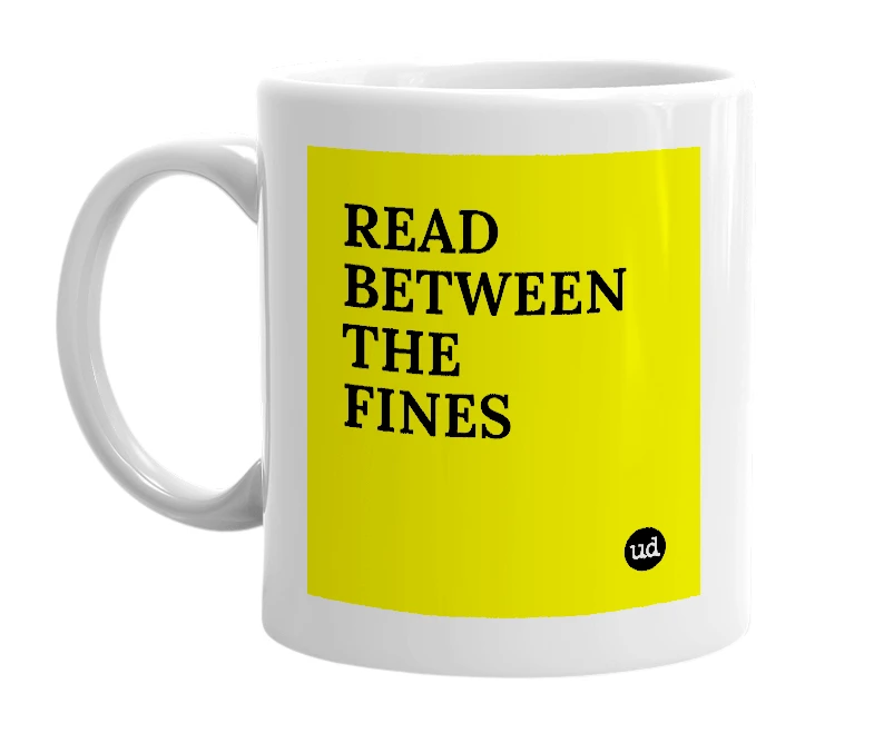 White mug with 'READ BETWEEN THE FINES' in bold black letters