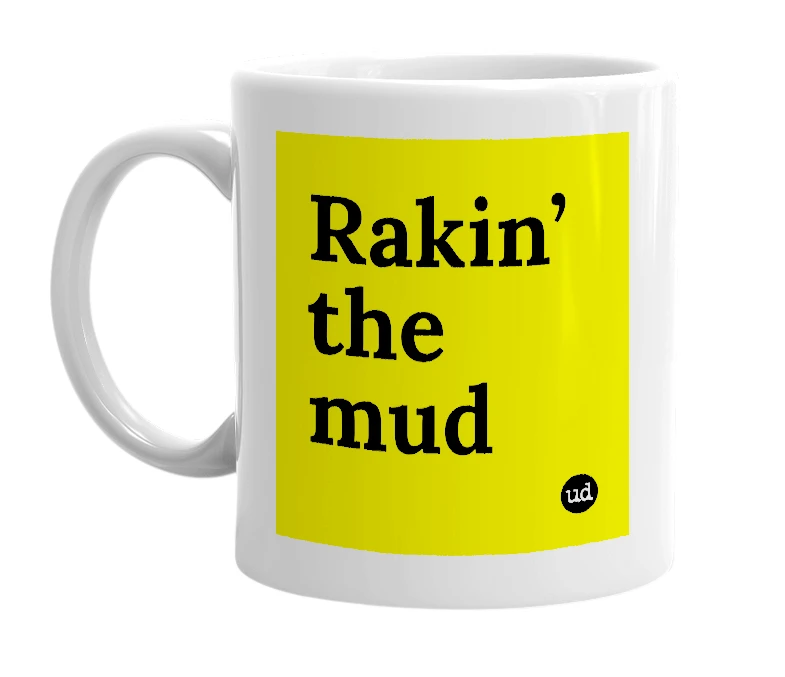 White mug with 'Rakin’ the mud' in bold black letters