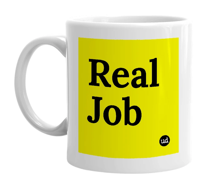 White mug with 'Real Job' in bold black letters