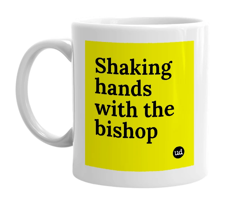 White mug with 'Shaking hands with the bishop' in bold black letters