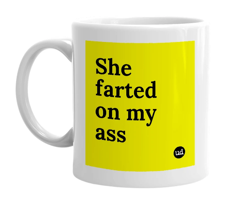White mug with 'She farted on my ass' in bold black letters