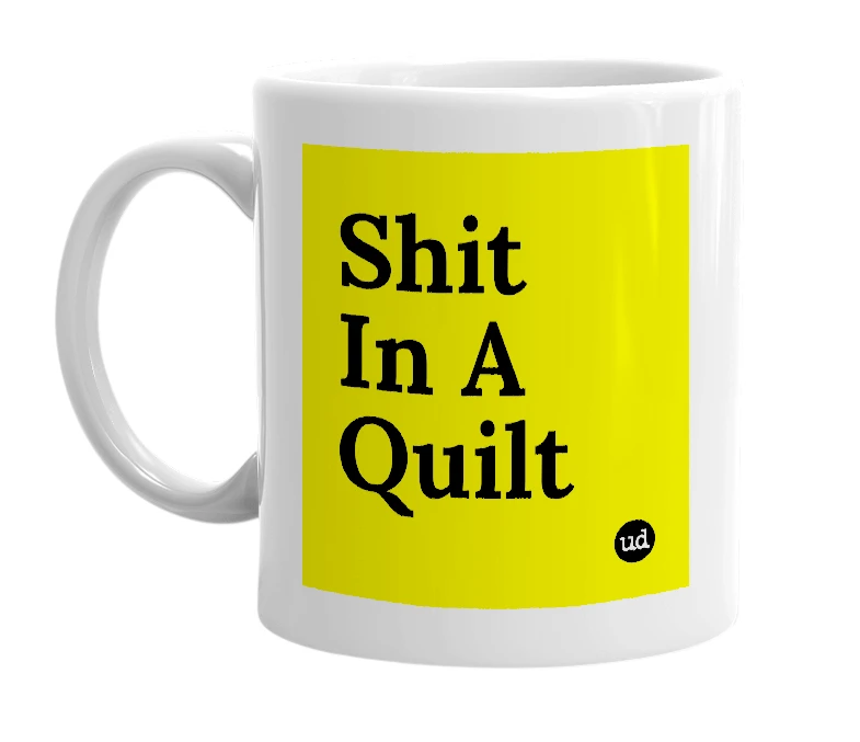 White mug with 'Shit In A Quilt' in bold black letters