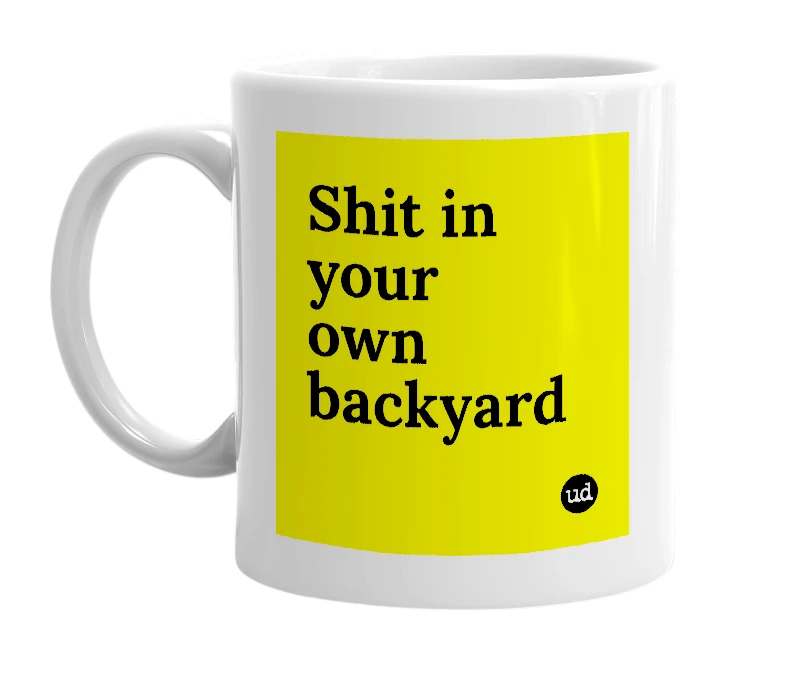 White mug with 'Shit in your own backyard' in bold black letters