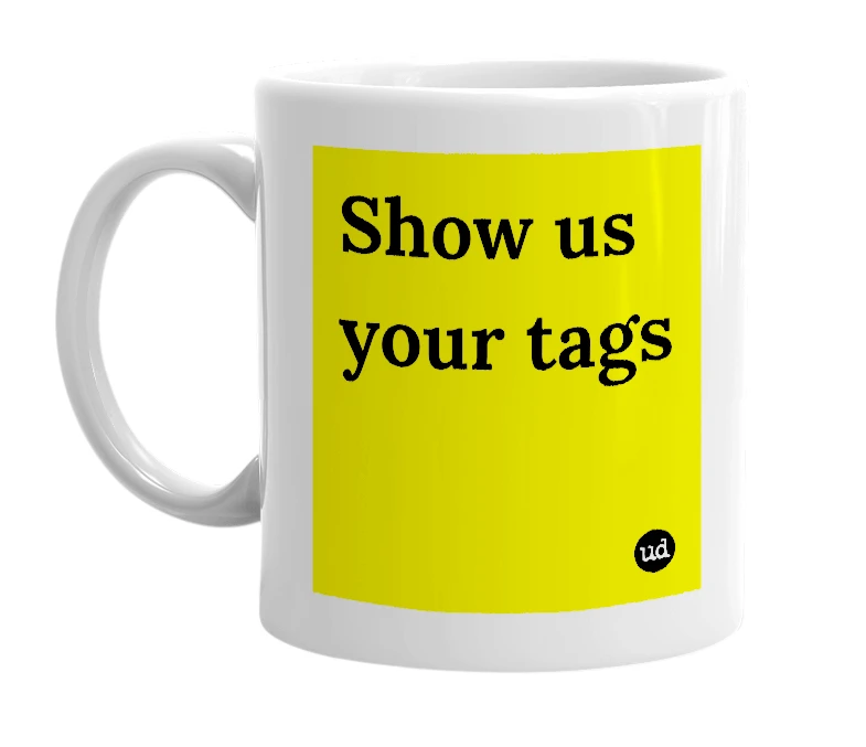 White mug with 'Show us your tags' in bold black letters