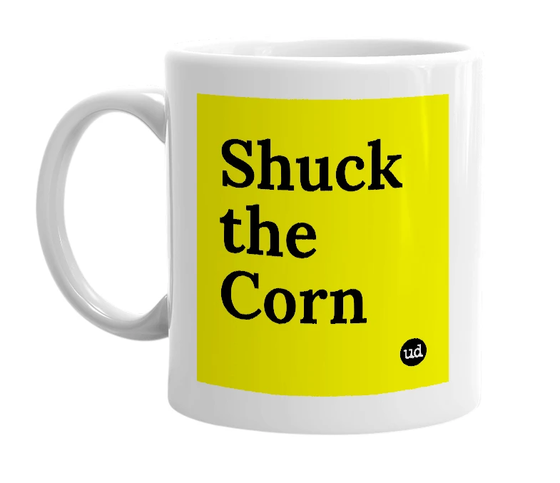 White mug with 'Shuck the Corn' in bold black letters