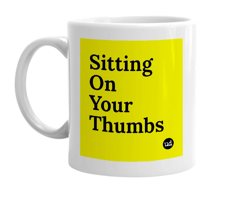 White mug with 'Sitting On Your Thumbs' in bold black letters