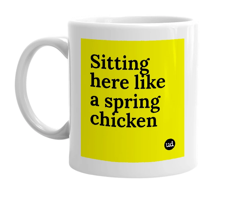 White mug with 'Sitting here like a spring chicken' in bold black letters