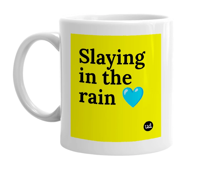 White mug with 'Slaying in the rain 💙' in bold black letters