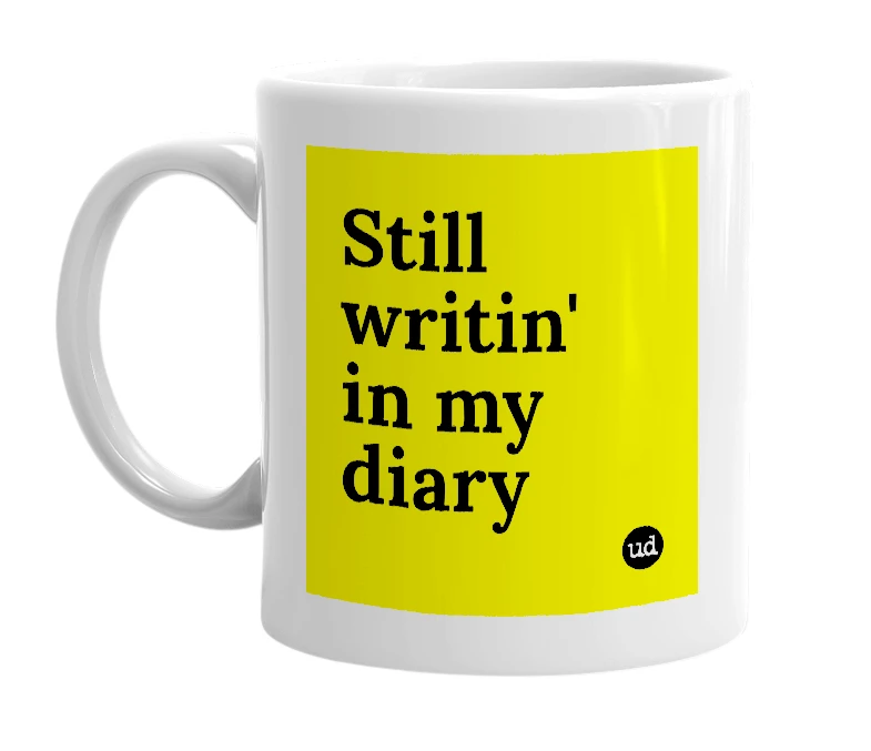 White mug with 'Still writin' in my diary' in bold black letters