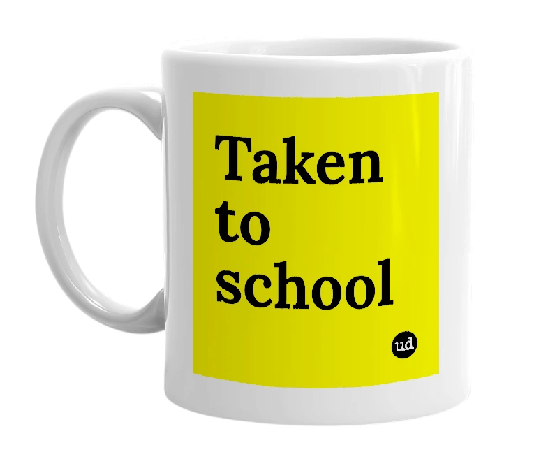 White mug with 'Taken to school' in bold black letters