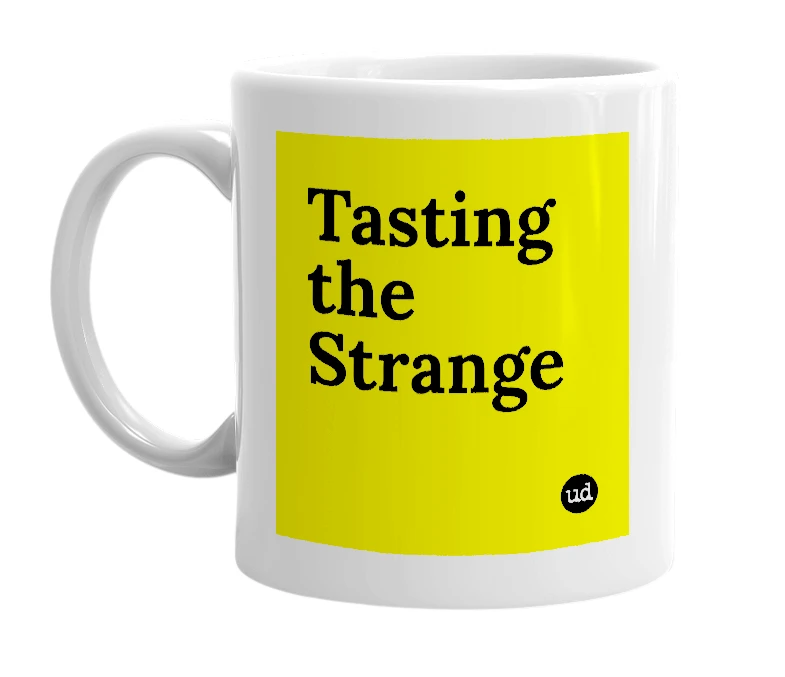 White mug with 'Tasting the Strange' in bold black letters