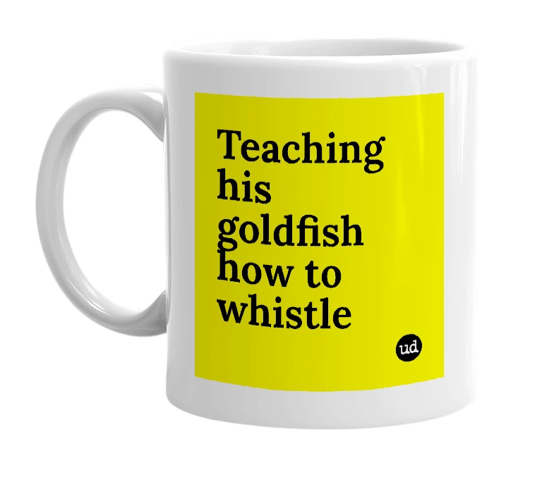 White mug with 'Teaching his goldfish how to whistle' in bold black letters