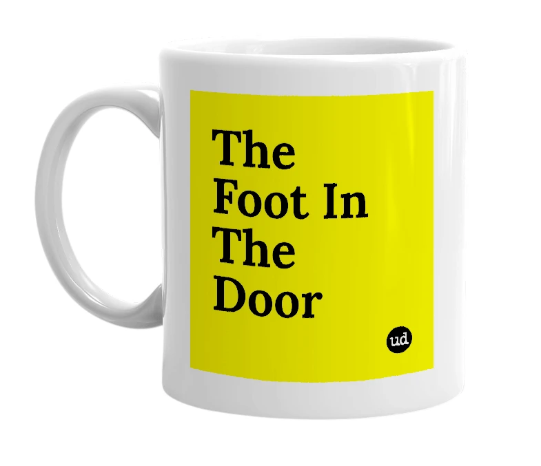 White mug with 'The Foot In The Door' in bold black letters