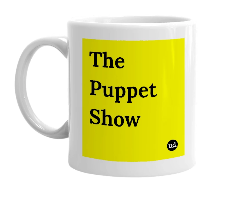 White mug with 'The Puppet Show' in bold black letters
