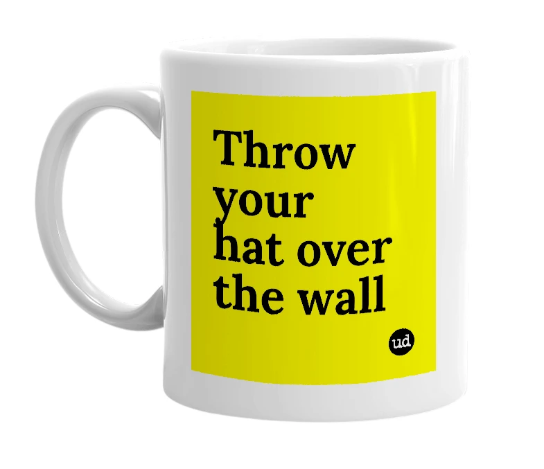 White mug with 'Throw your hat over the wall' in bold black letters