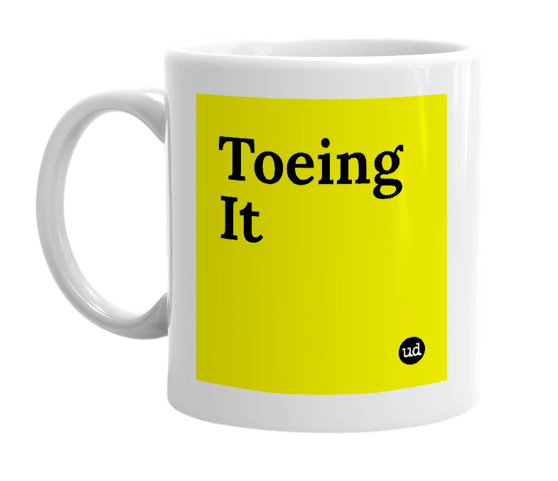 White mug with 'Toeing It' in bold black letters