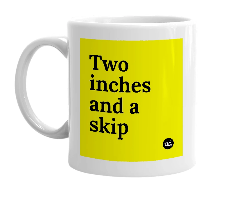 White mug with 'Two inches and a skip' in bold black letters