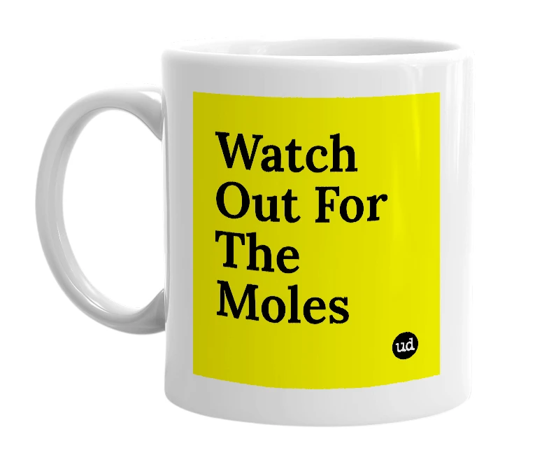 White mug with 'Watch Out For The Moles' in bold black letters