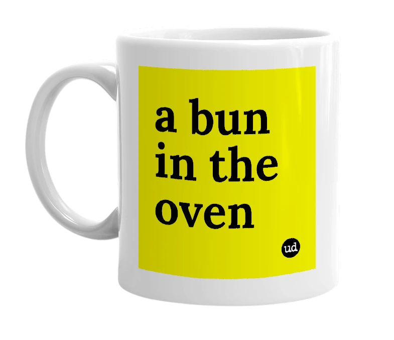 White mug with 'a bun in the oven' in bold black letters