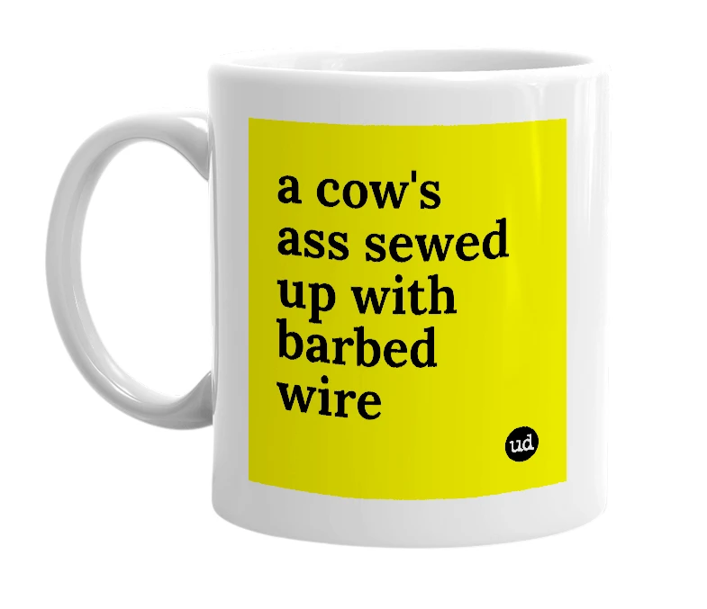 White mug with 'a cow's ass sewed up with barbed wire' in bold black letters