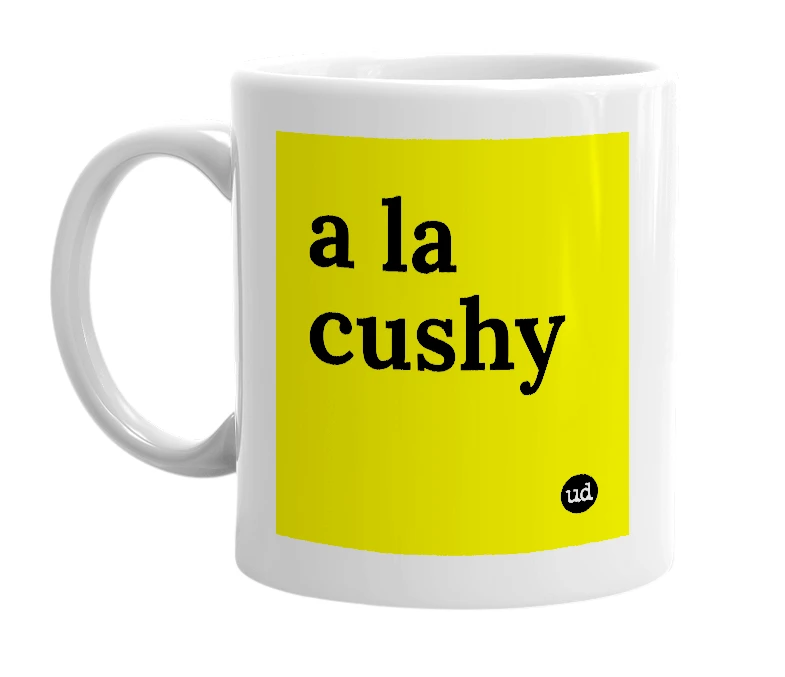 White mug with 'a la cushy' in bold black letters