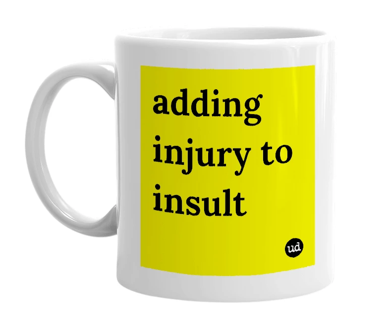 White mug with 'adding injury to insult' in bold black letters