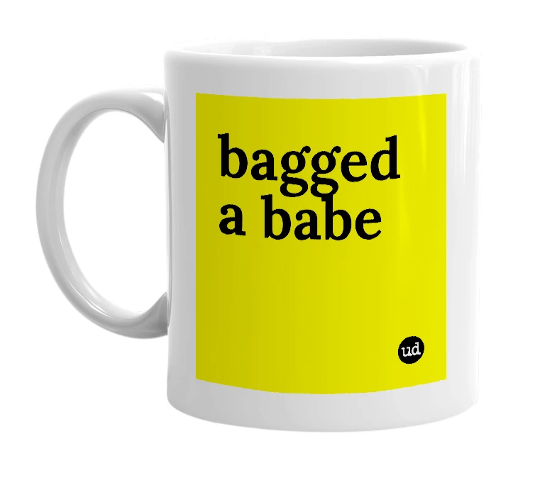 White mug with 'bagged a babe' in bold black letters