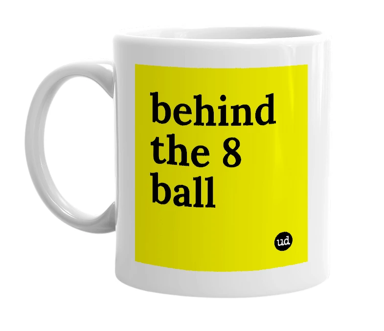 White mug with 'behind the 8 ball' in bold black letters