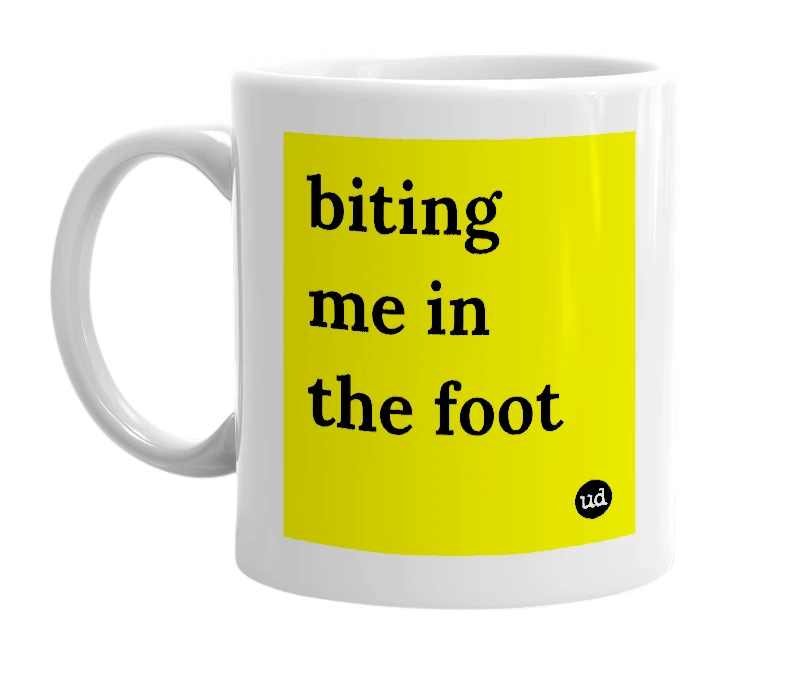 White mug with 'biting me in the foot' in bold black letters