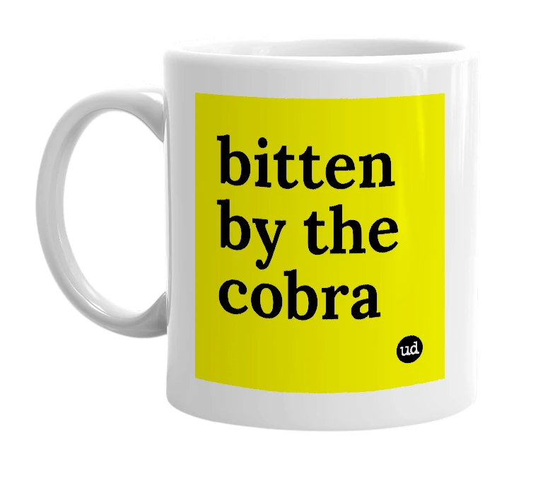 White mug with 'bitten by the cobra' in bold black letters