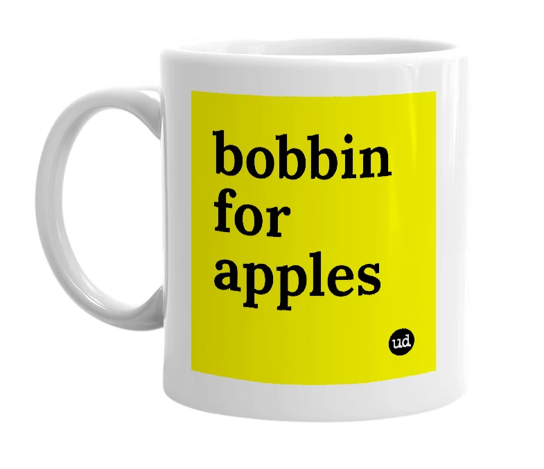 White mug with 'bobbin for apples' in bold black letters
