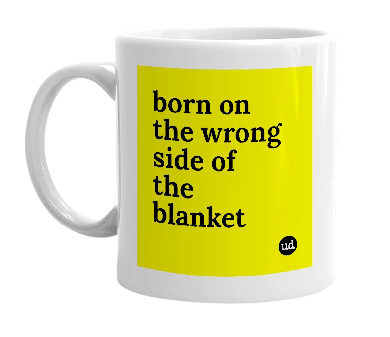 White mug with 'born on the wrong side of the blanket' in bold black letters