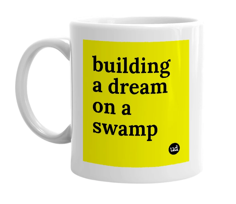 White mug with 'building a dream on a swamp' in bold black letters