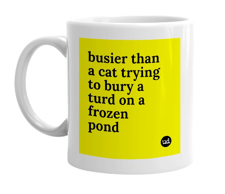 White mug with 'busier than a cat trying to bury a turd on a frozen pond' in bold black letters