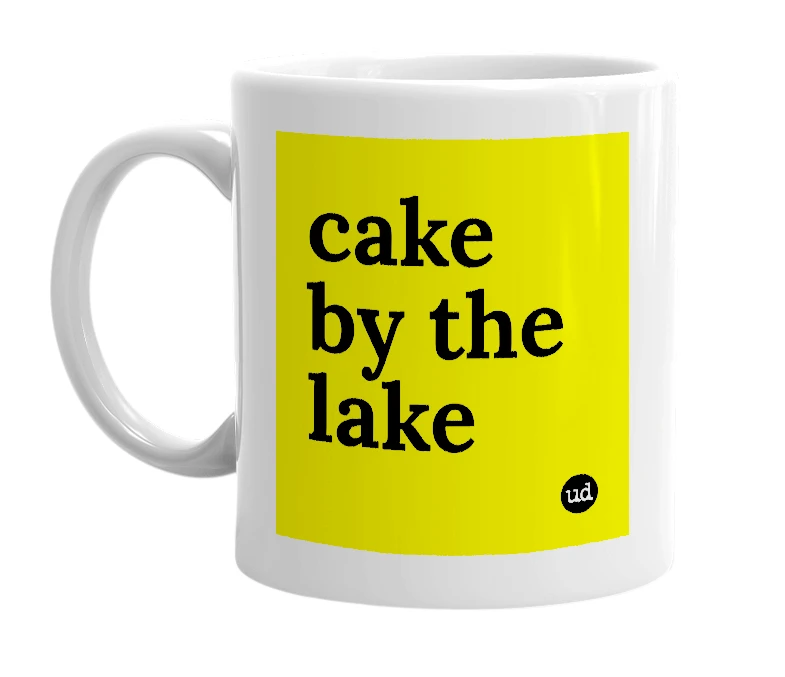White mug with 'cake by the lake' in bold black letters