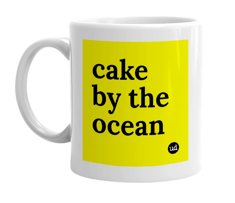White mug with 'cake by the ocean' in bold black letters