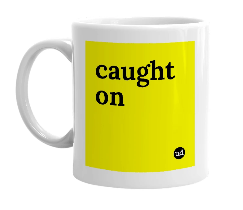 White mug with 'caught on' in bold black letters