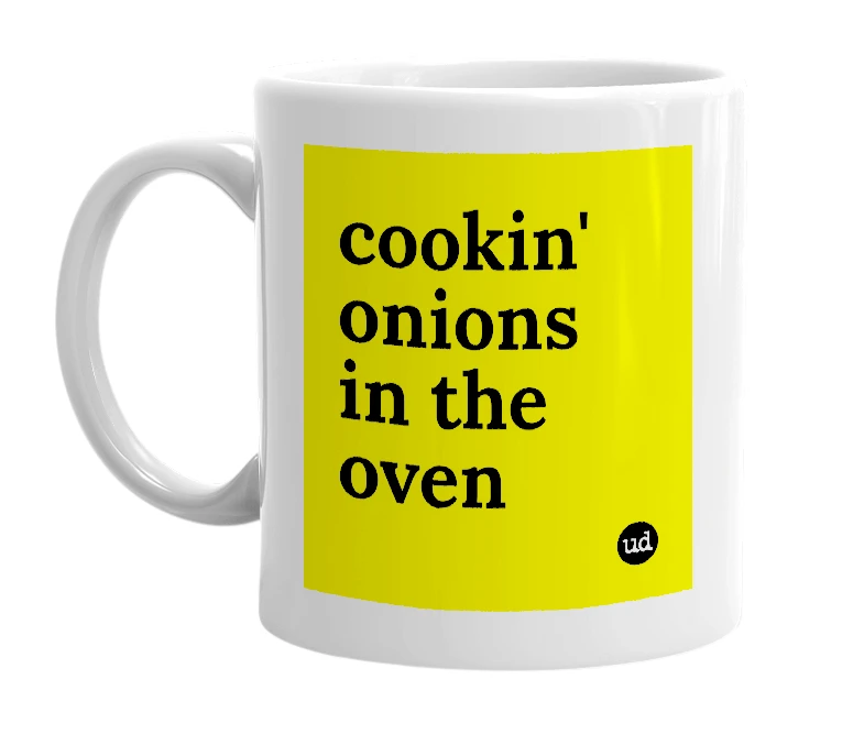 White mug with 'cookin' onions in the oven' in bold black letters