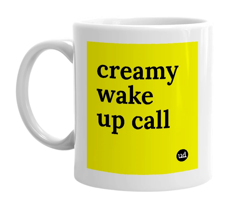 White mug with 'creamy wake up call' in bold black letters