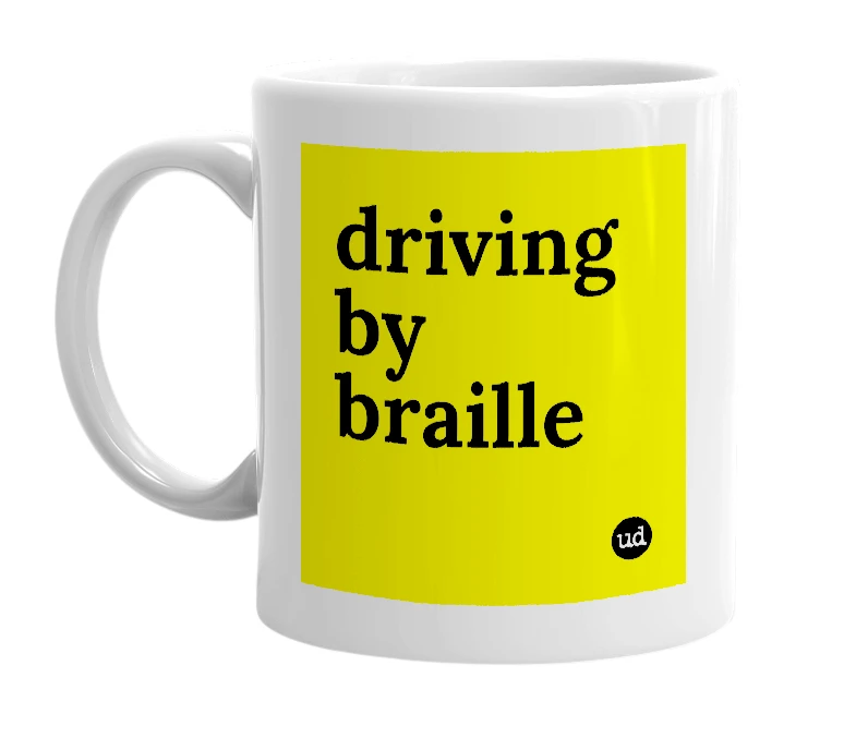 White mug with 'driving by braille' in bold black letters