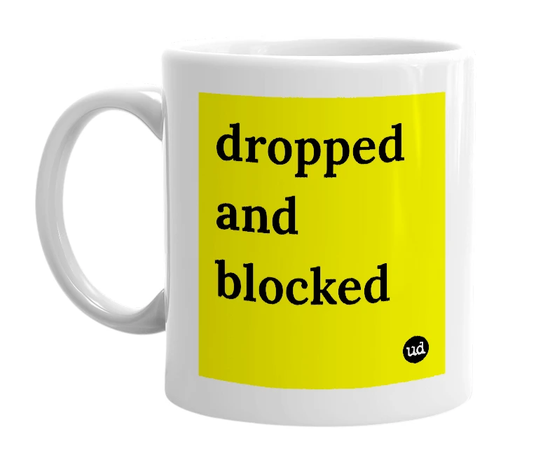 White mug with 'dropped and blocked' in bold black letters