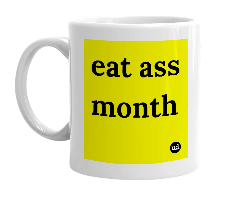 White mug with 'eat ass month' in bold black letters
