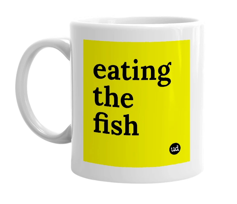 White mug with 'eating the fish' in bold black letters